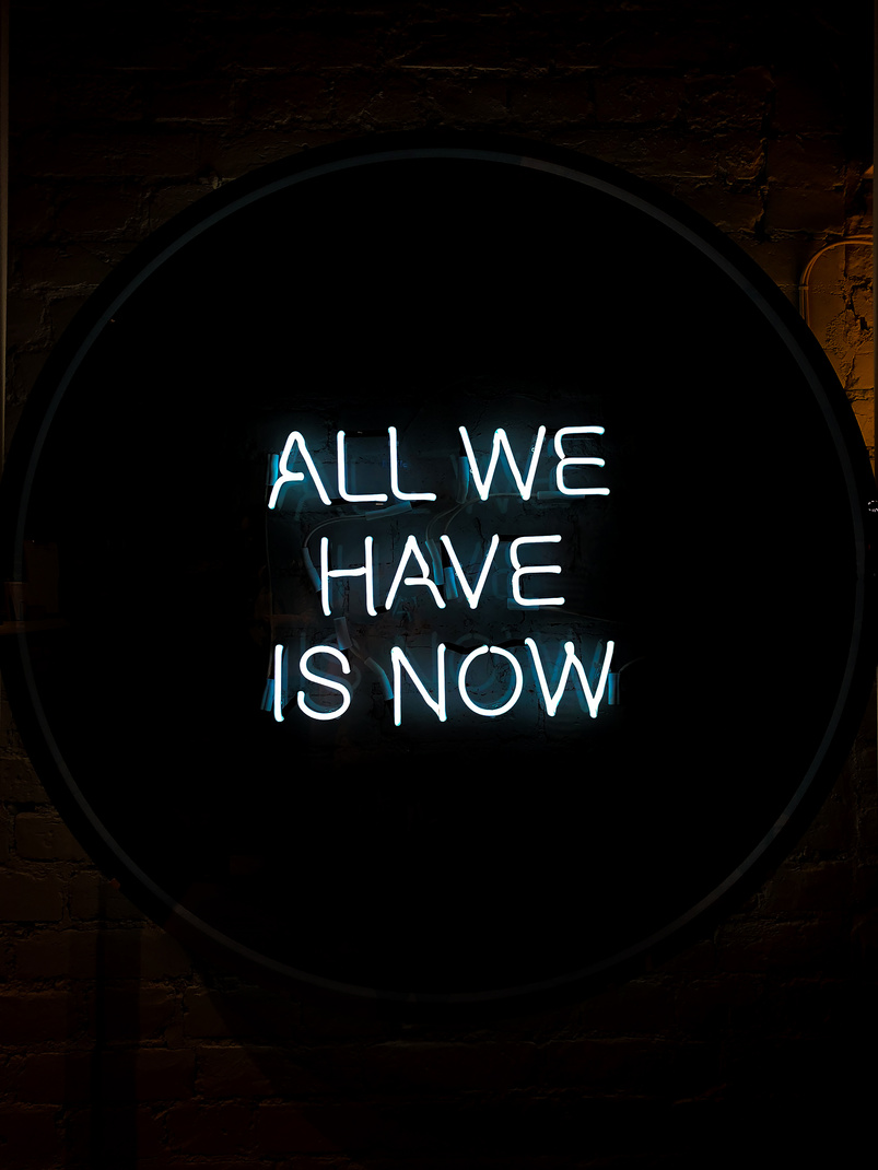 All We Have Is Now Neon Signage on Black Surface